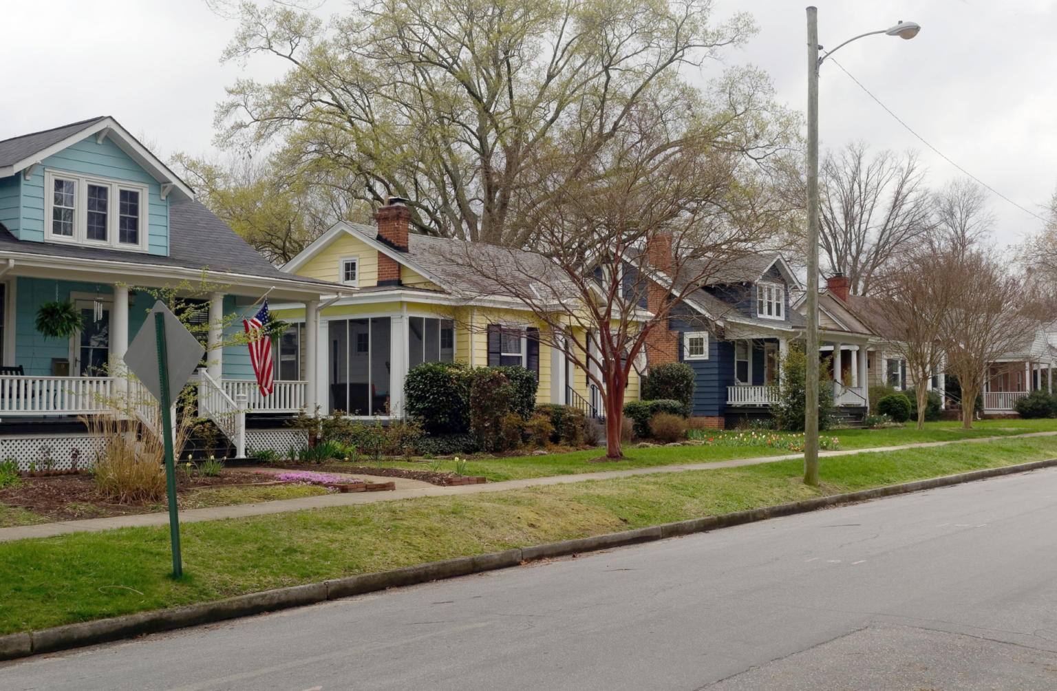 A row of houses are lined up on the side of a street