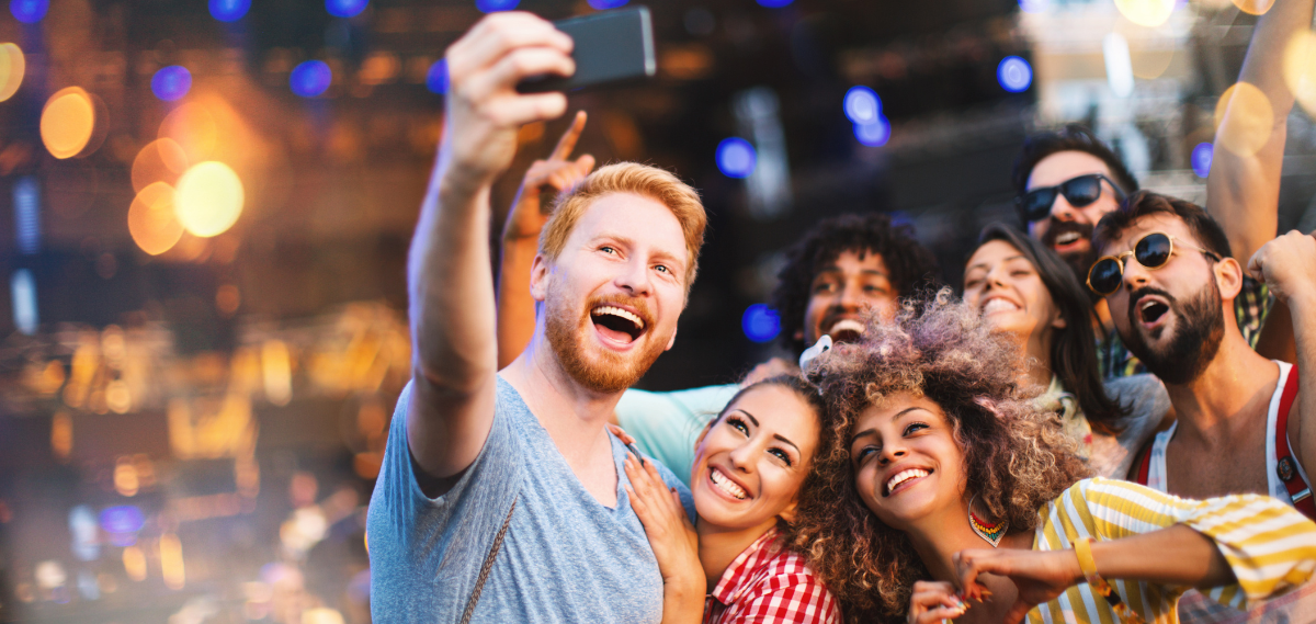 A group of people are taking a selfie with a cell phone.