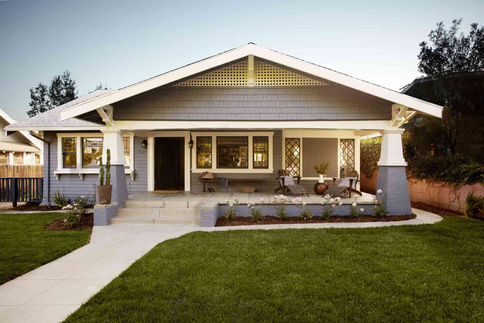 A gray and white house with a large porch