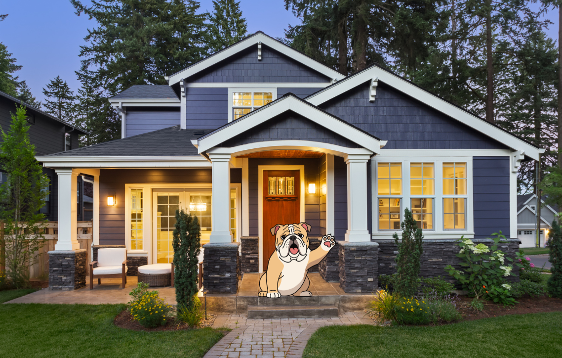 Blue two-story house with lit porch and a dog sitting on the front steps at dusk