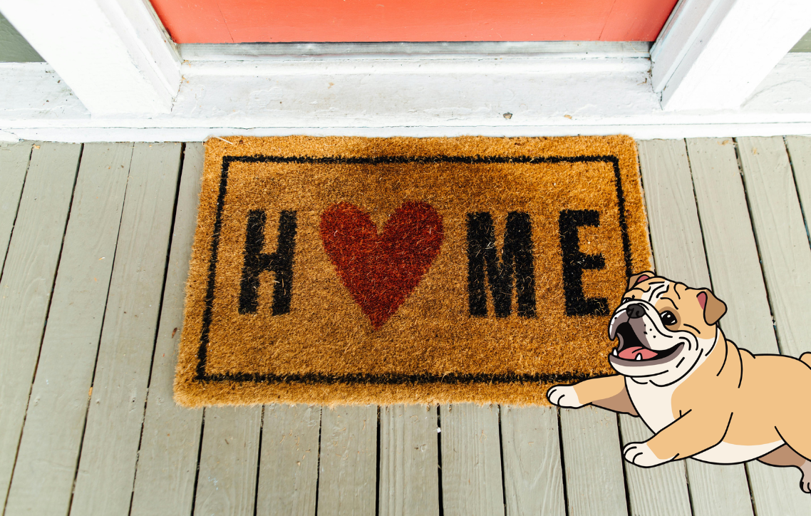 Doormat with “HOME” and a heart on a porch, with a bulldog standing at the right edge.