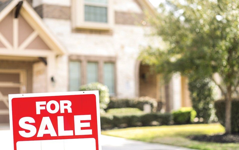 A for sale sign in front of a house