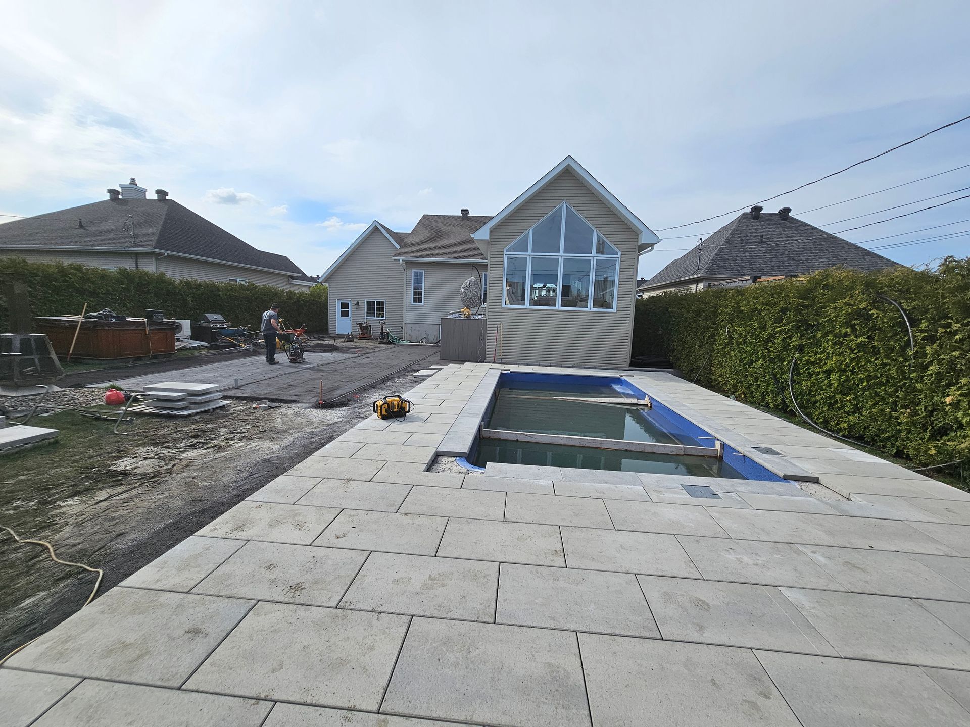 A swimming pool is being built in the backyard of a house.