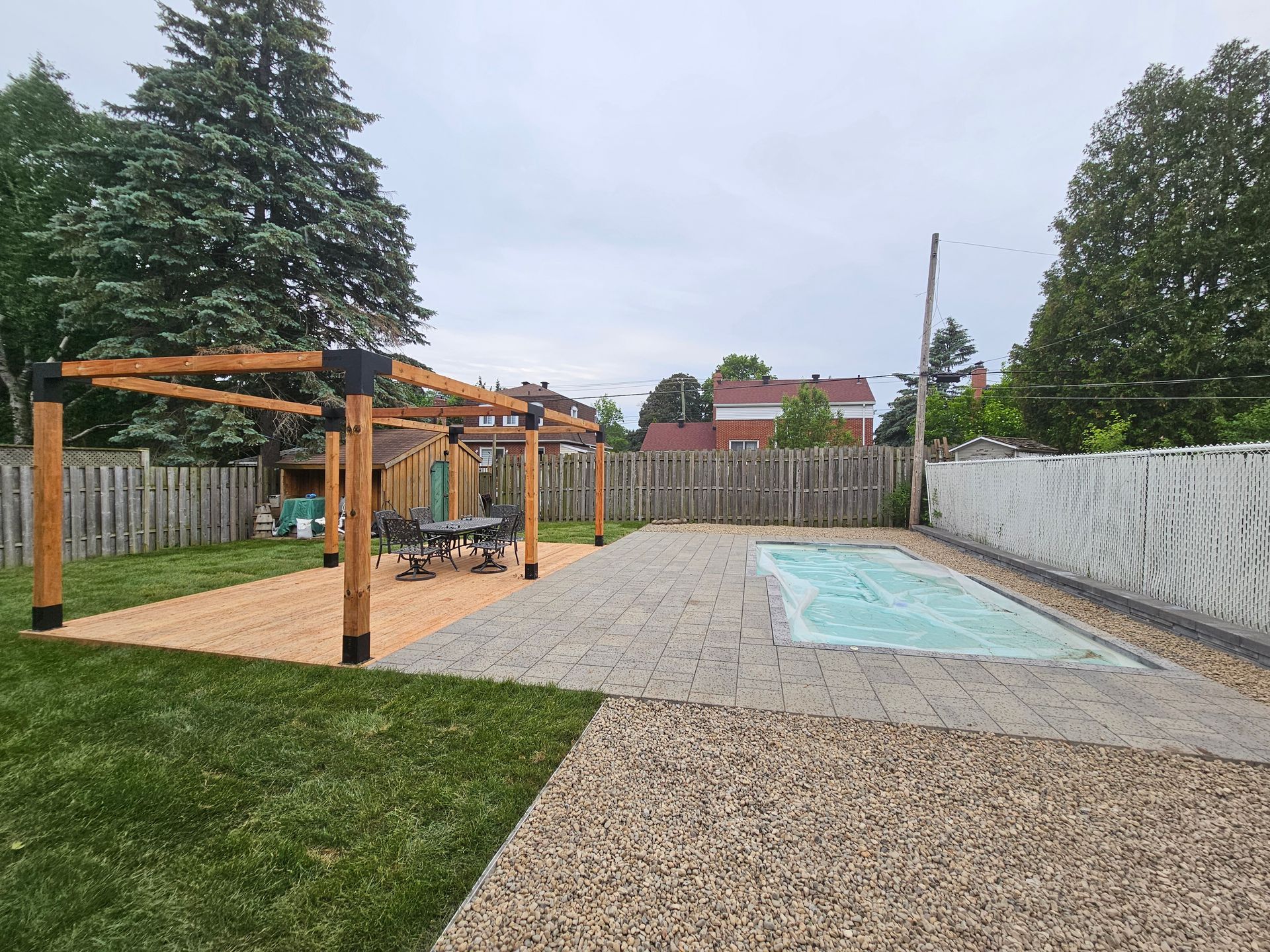 A backyard with a swimming pool and a pergola.