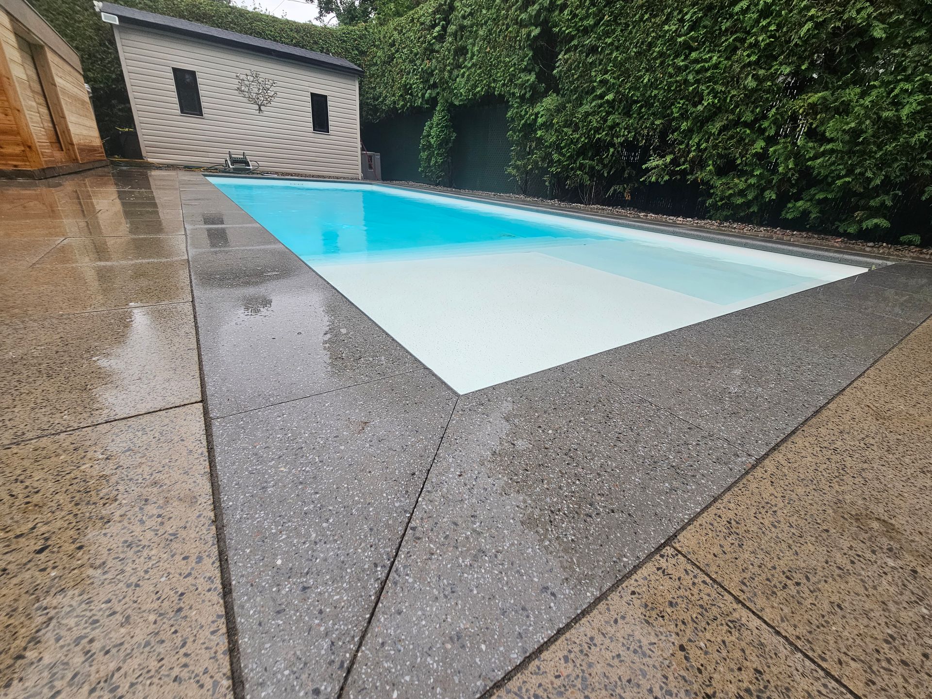 A large swimming pool with a house in the background