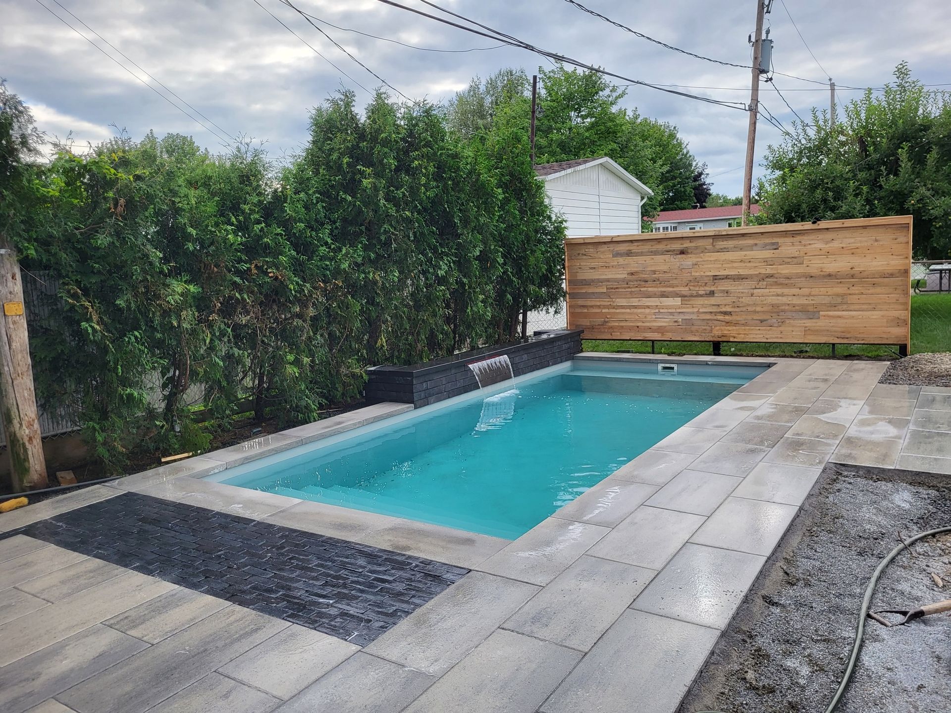A small swimming pool is surrounded by a wooden fence.