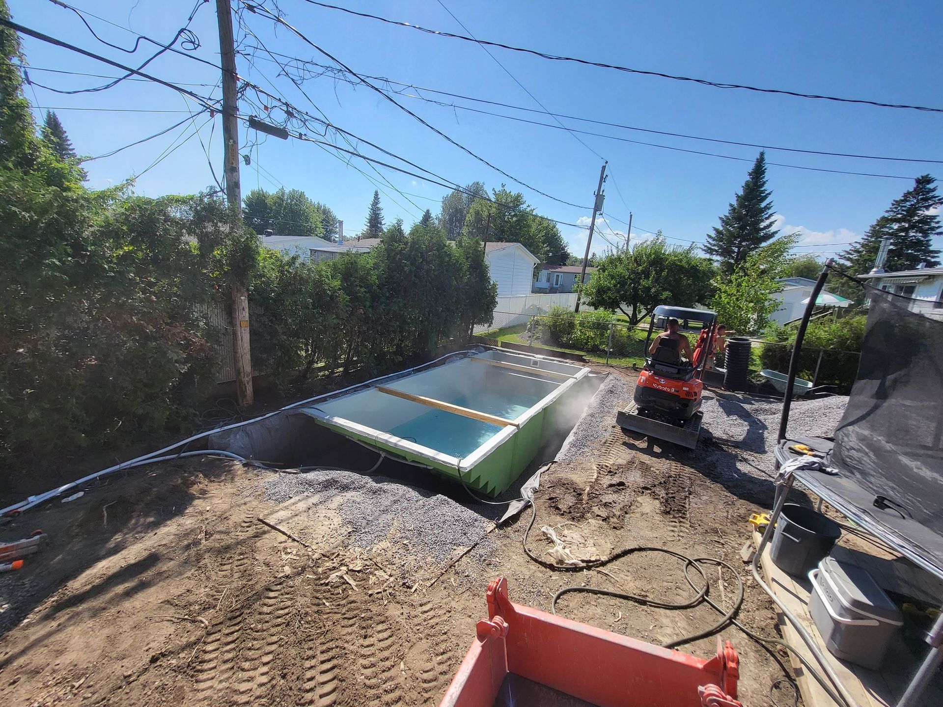 A swimming pool is being built in the backyard of a house