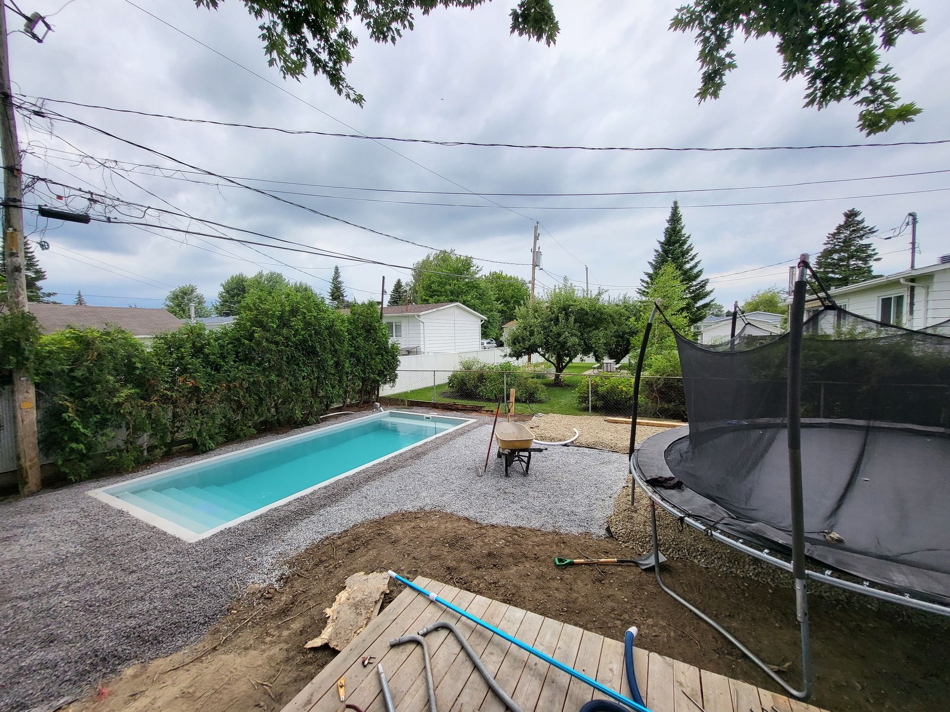 A large swimming pool is being built in the backyard of a house.