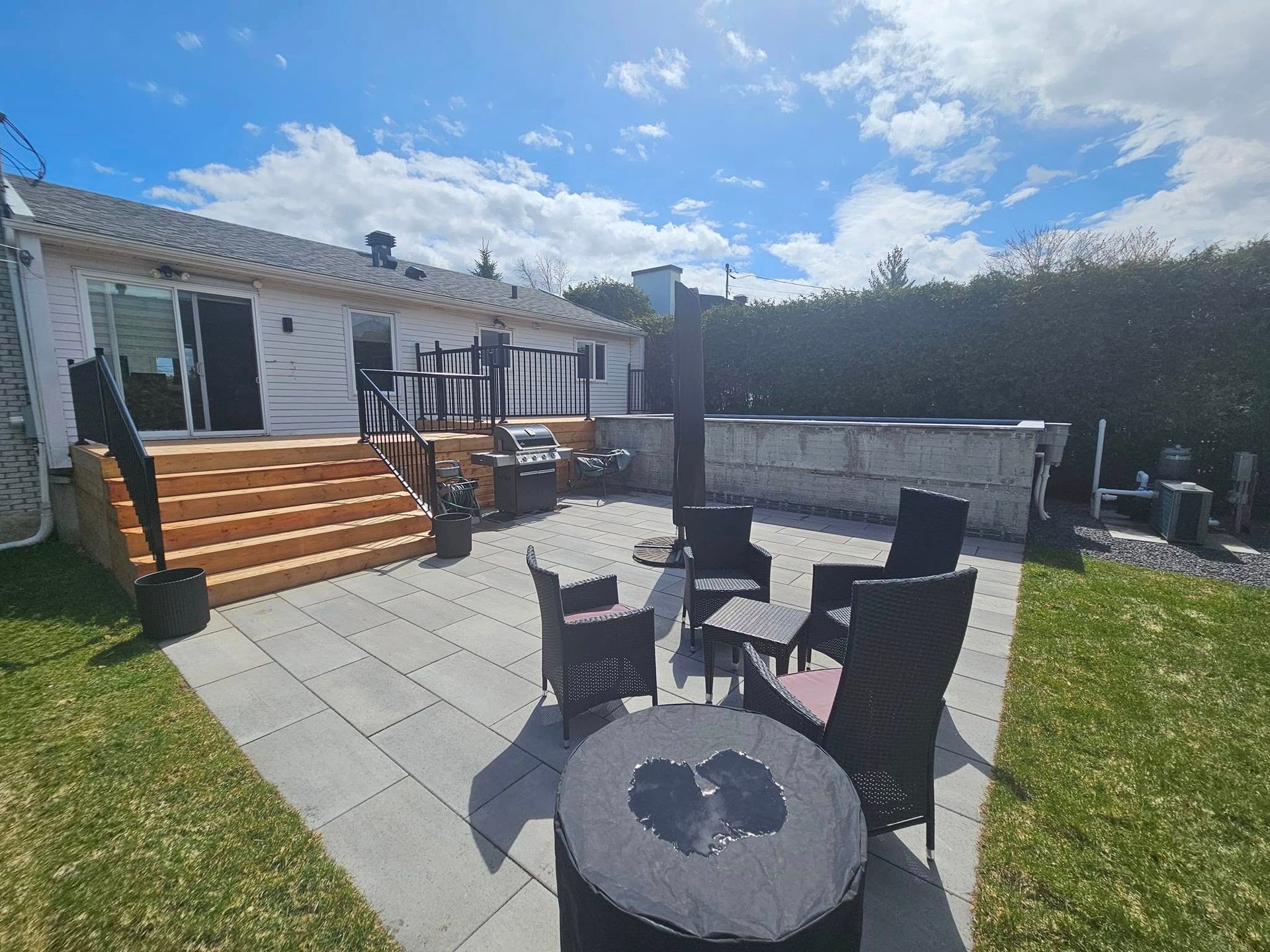 A patio with a table and chairs in front of a house.