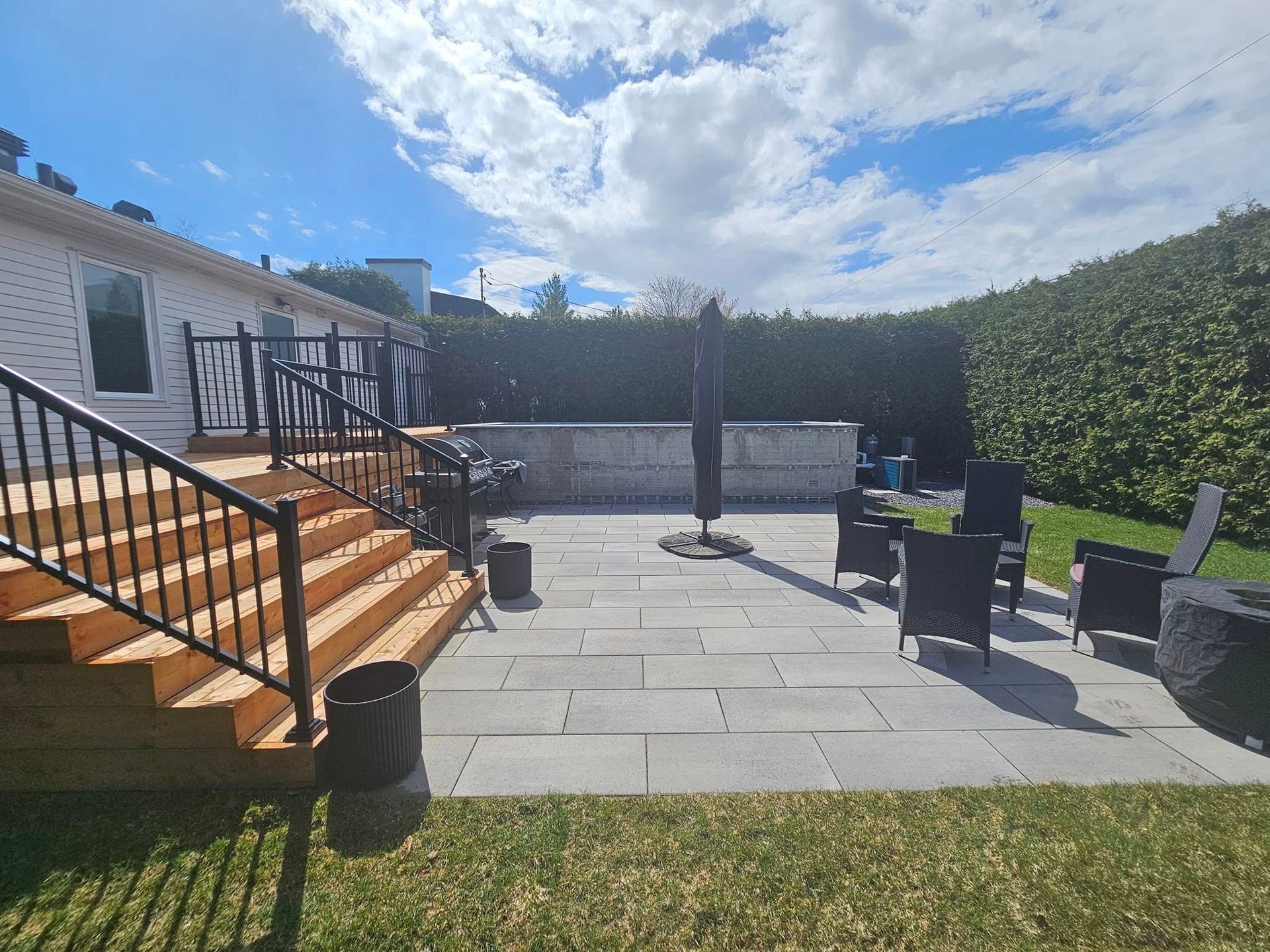 A patio with stairs and chairs in front of a house.