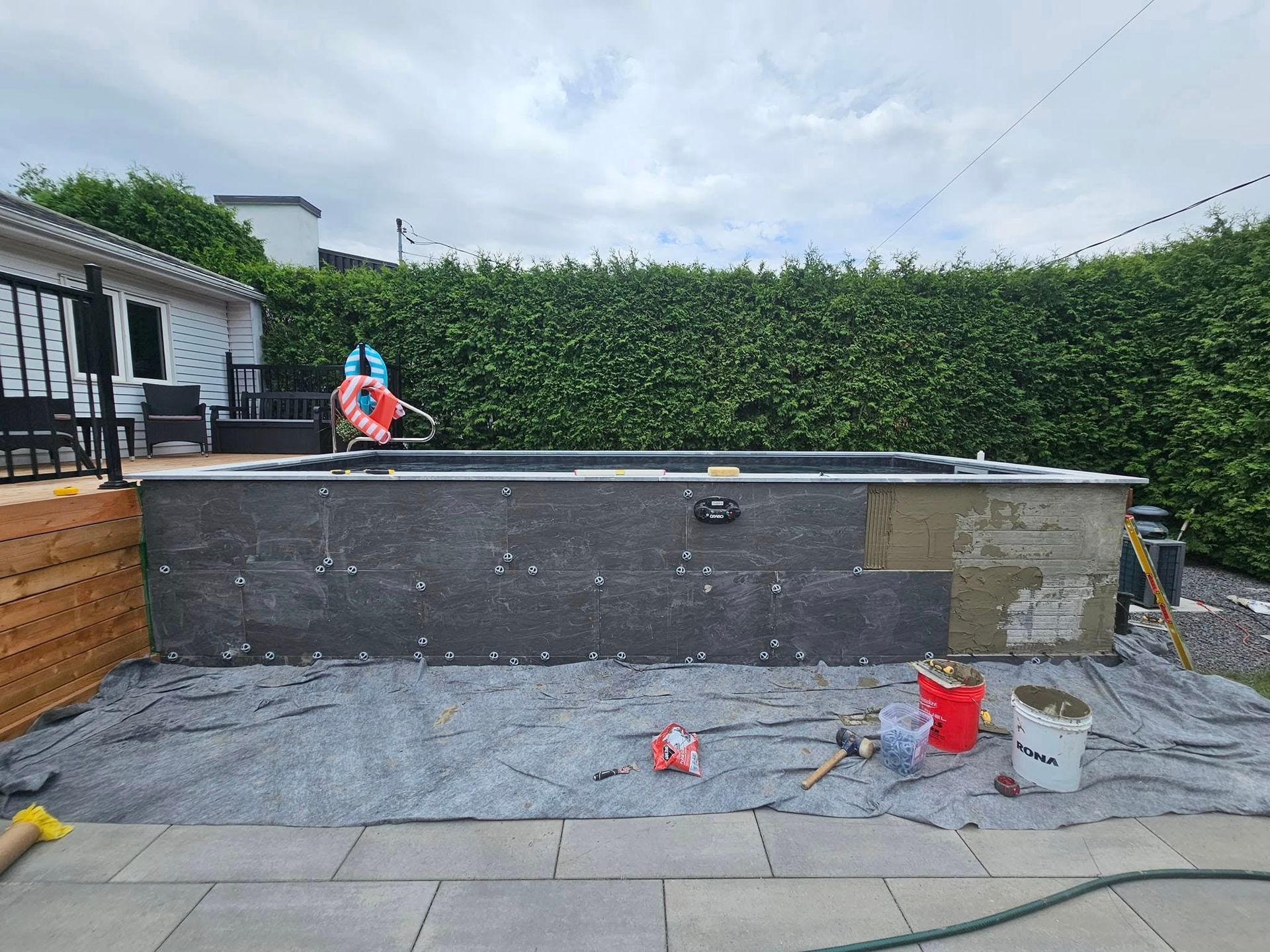 A large swimming pool is being built in a backyard.