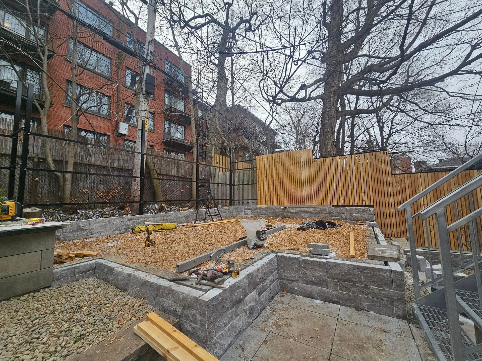 A construction site with a fence and stairs in front of a building.