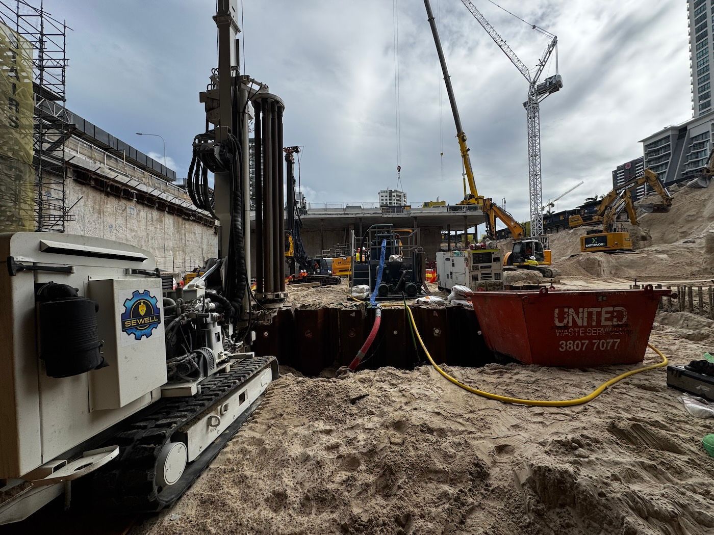 Deep well drilling rig installing dewatering well on construction site