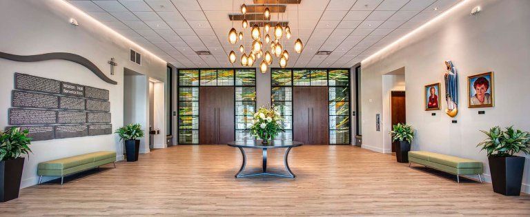 A large room with a table in the middle and a chandelier hanging from the ceiling.