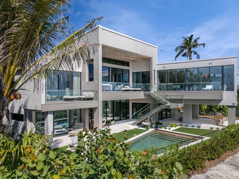 a large white house sits in the middle of a lush green lawn