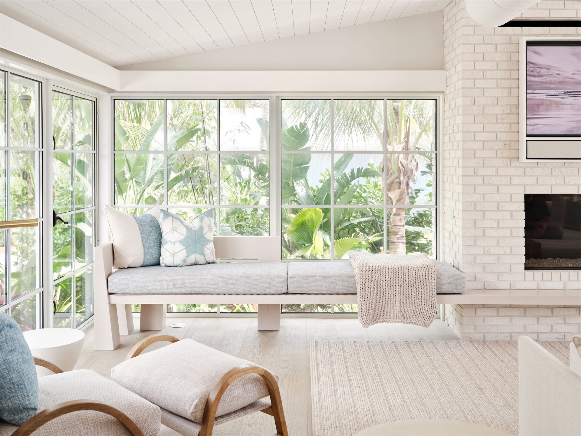 a living room with a couch, a large picture window, and a fireplace