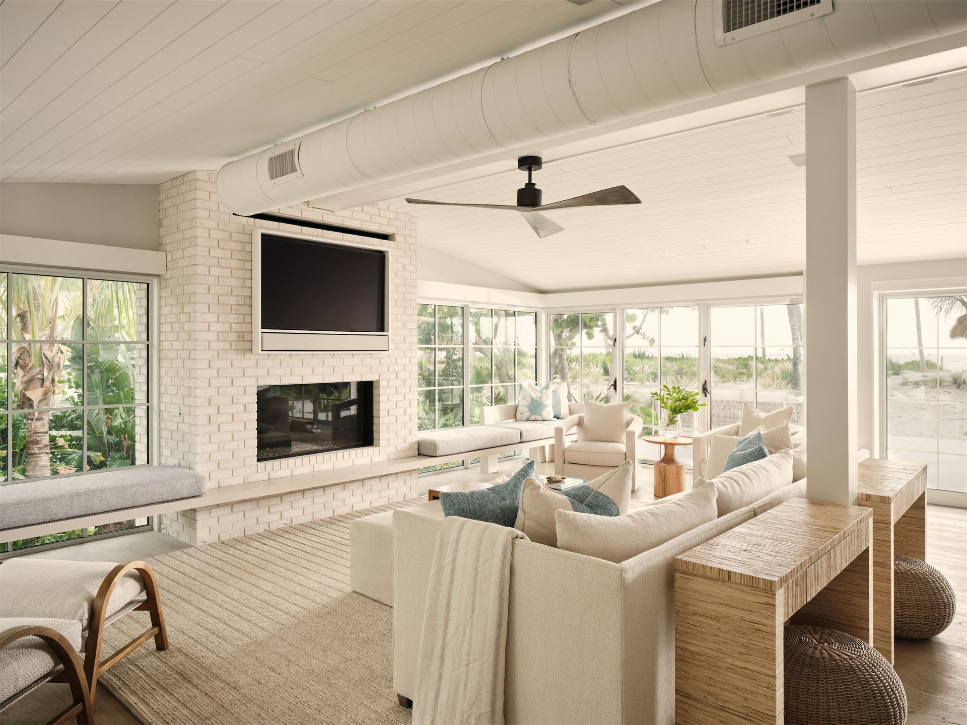 an all-white living room with a fireplace and a flat screen tv