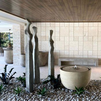 A room with a fountain and sculptures in it
