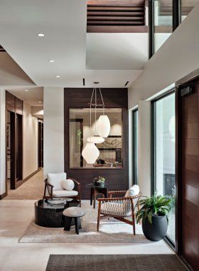 A living room with chairs , a table , and a mirror.