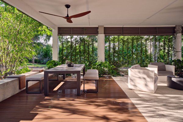 A patio with a table and chairs and a ceiling fan.