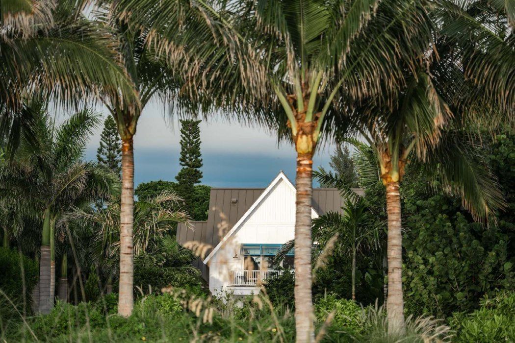 a large white house sits in the middle of a lush green lawn