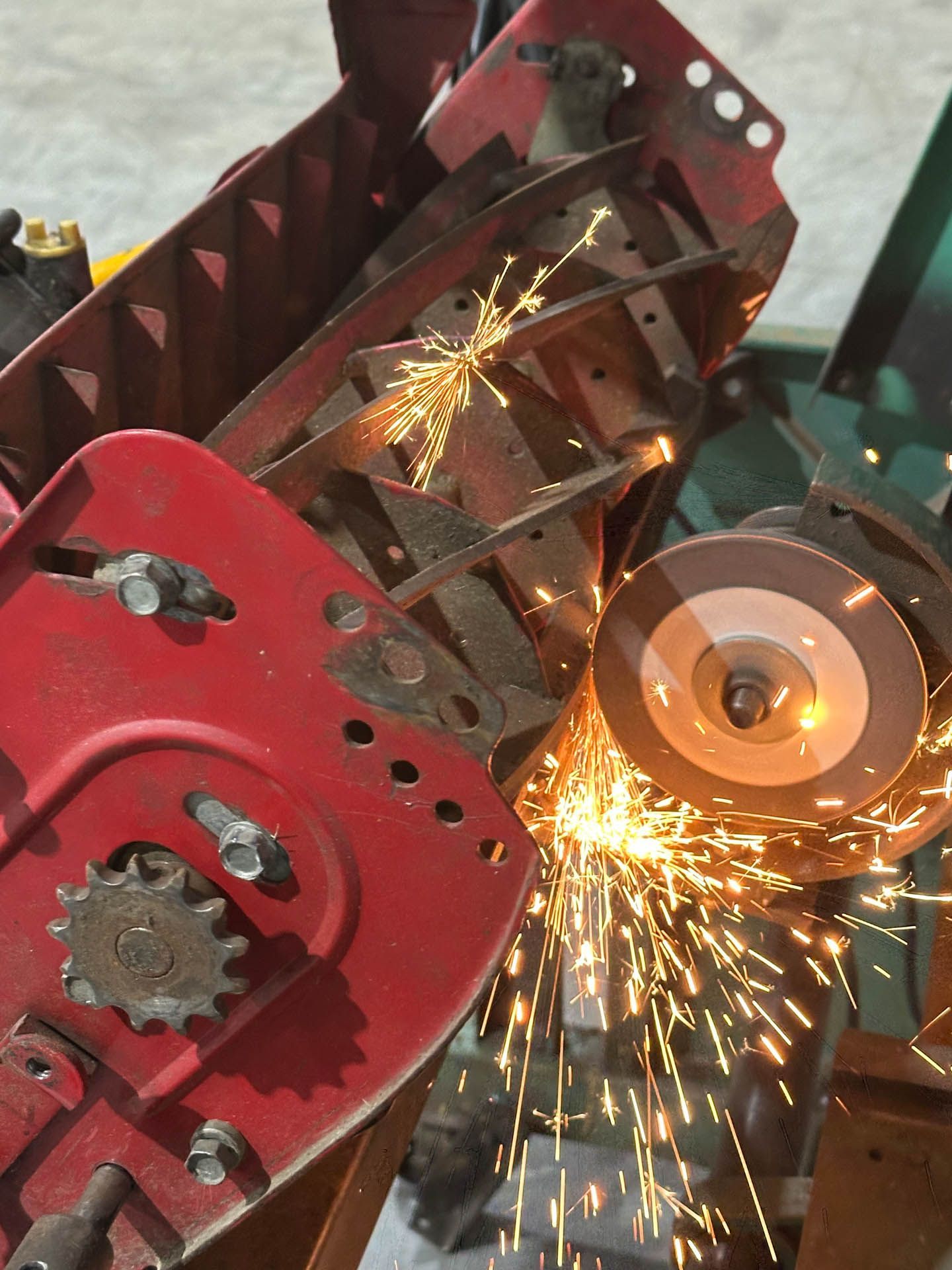 A machine is being used to sharpen a REEL MOWER blade