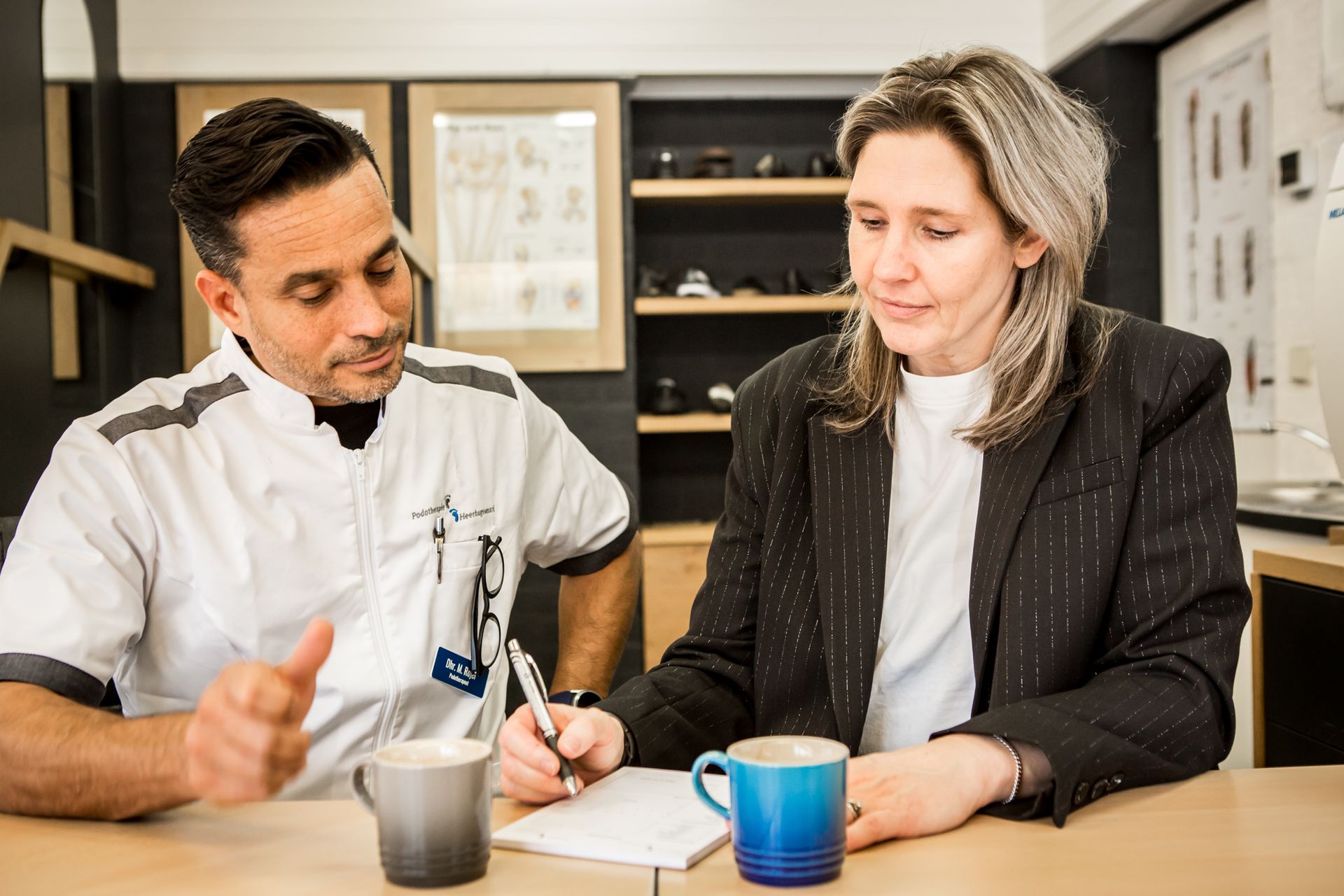 Een man en een vrouw zitten aan een tafel met elkaar te praten.