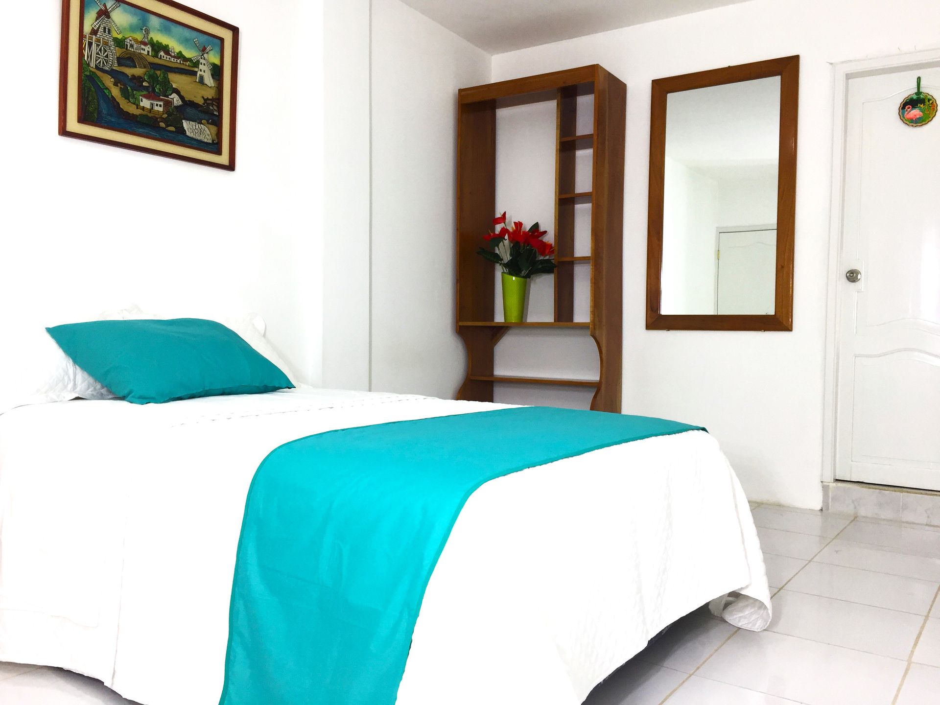 Un dormitorio con una cama y un espejo en la pared.