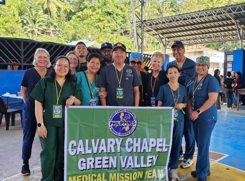 Group of volunteers posing with a “Calvary Chapel Green Valley” banner at an outdoor event