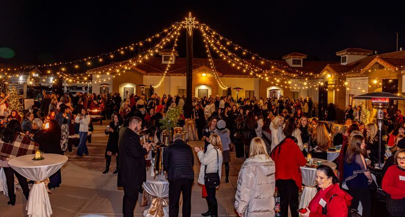 Crowded outdoor night market with string lights and people mingling in winter jackets