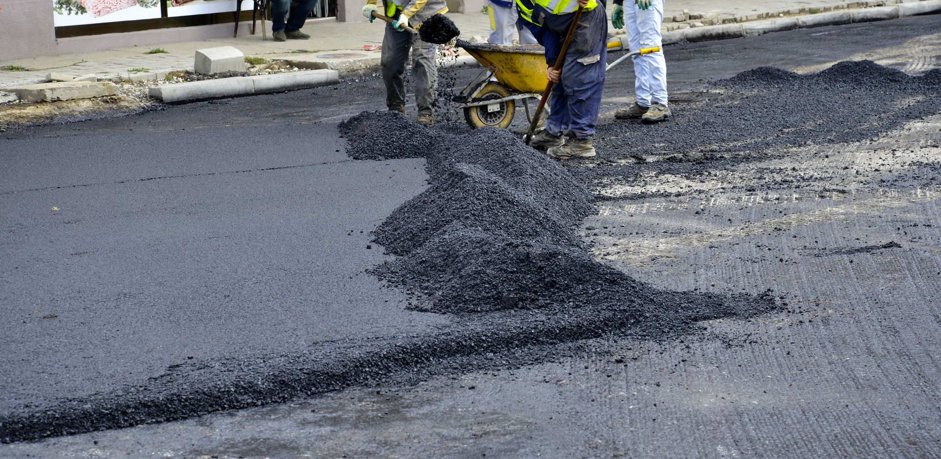 A group of construction workers are working on a road.