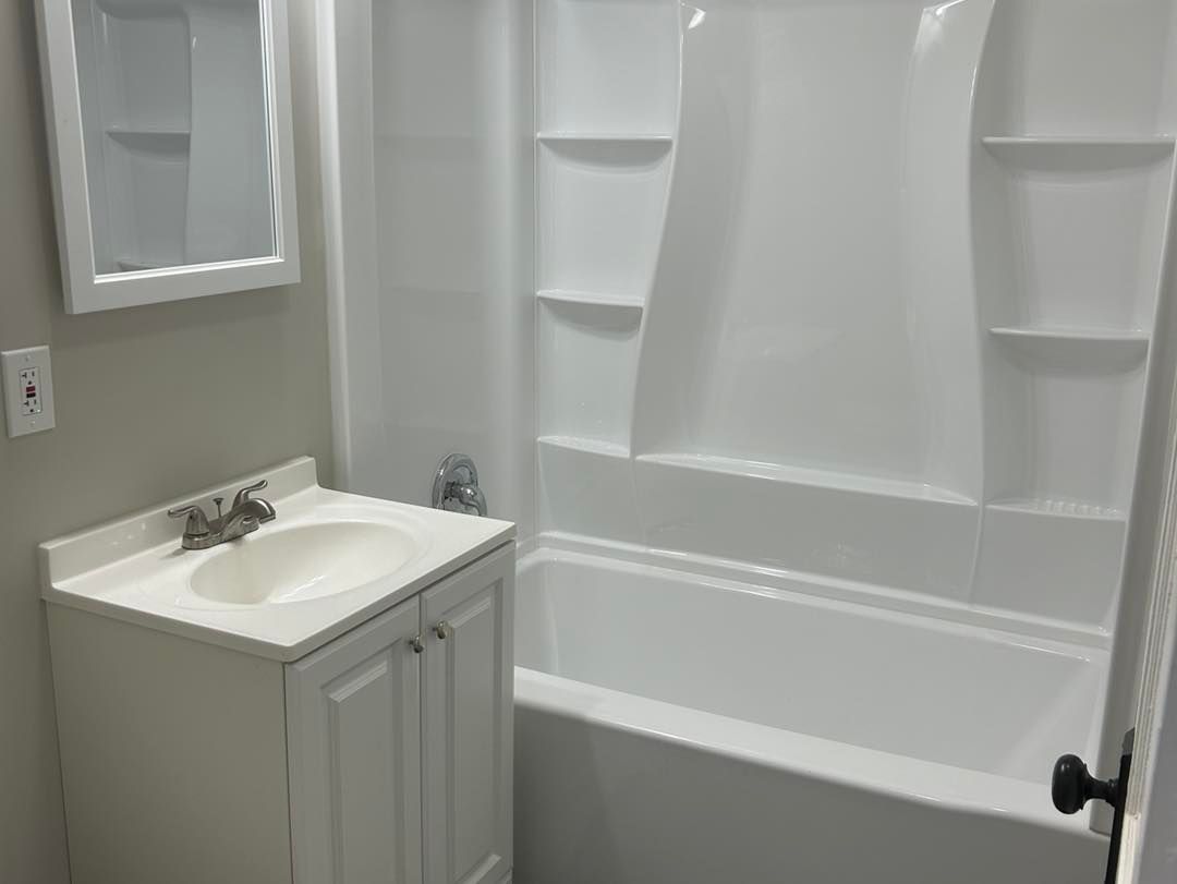 A bathroom with a sink , bathtub and mirror.