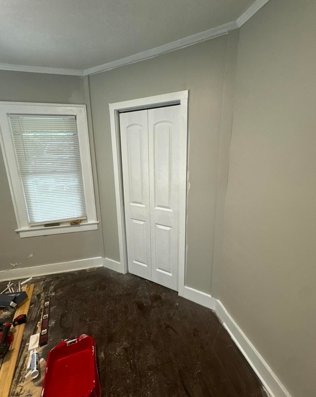 A room with a closet , two windows , and a red chair.