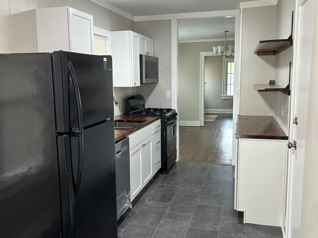 A kitchen with a black refrigerator , stove , dishwasher , and microwave.