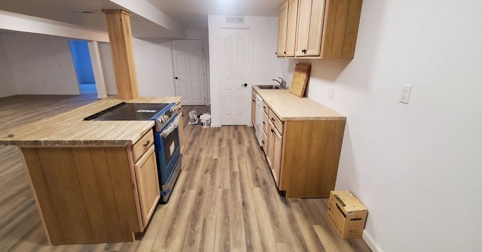 A kitchen with wooden cabinets , a stove , and a sink.