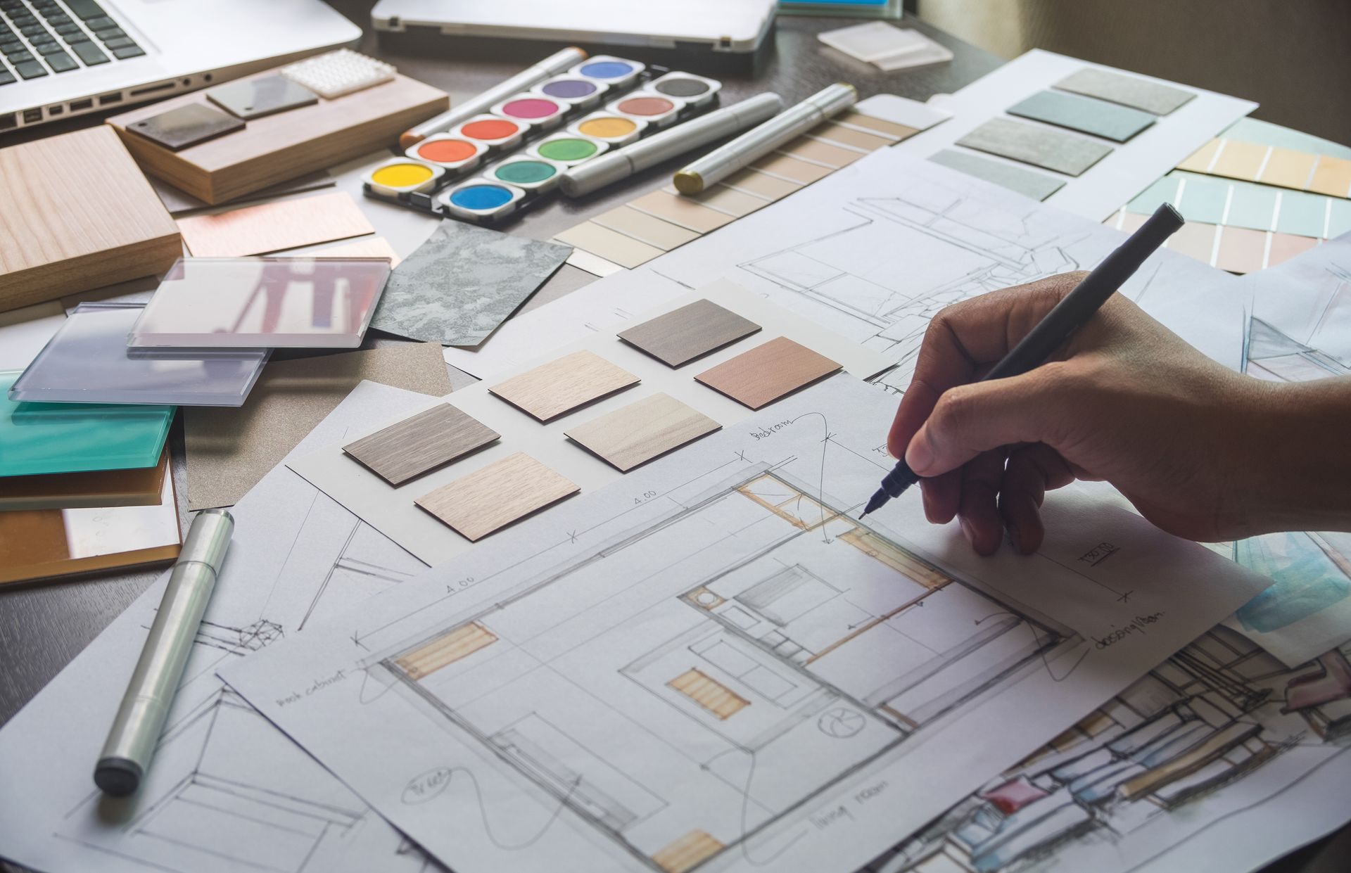 A person is drawing a floor plan of a house.