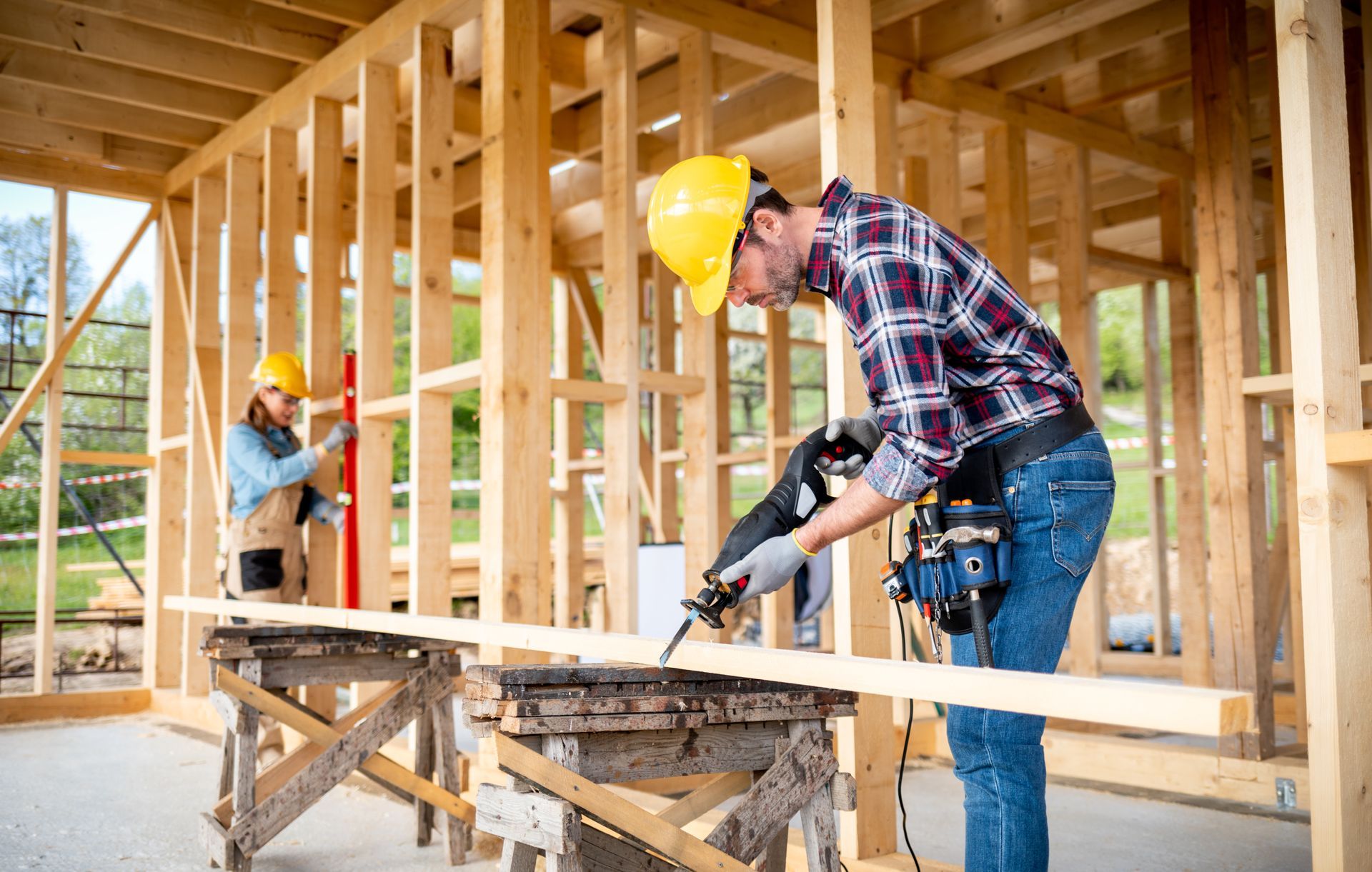 A man is using a saw to cut a piece of wood.