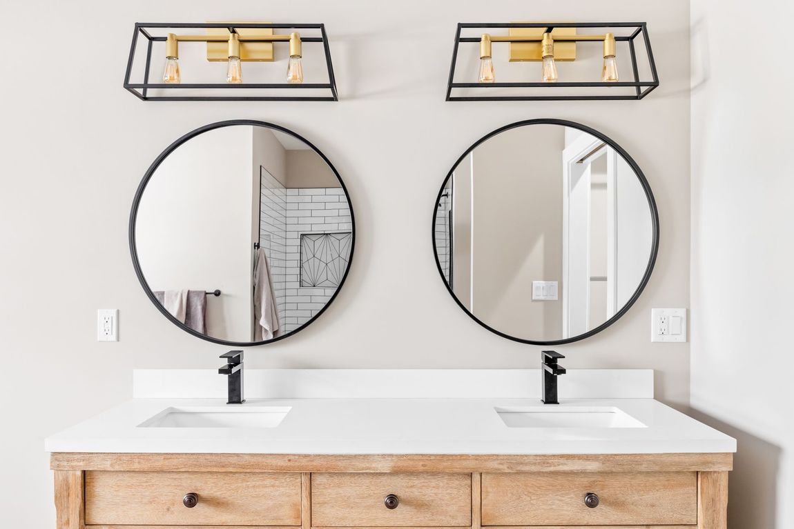 A bathroom with two sinks and two mirrors.