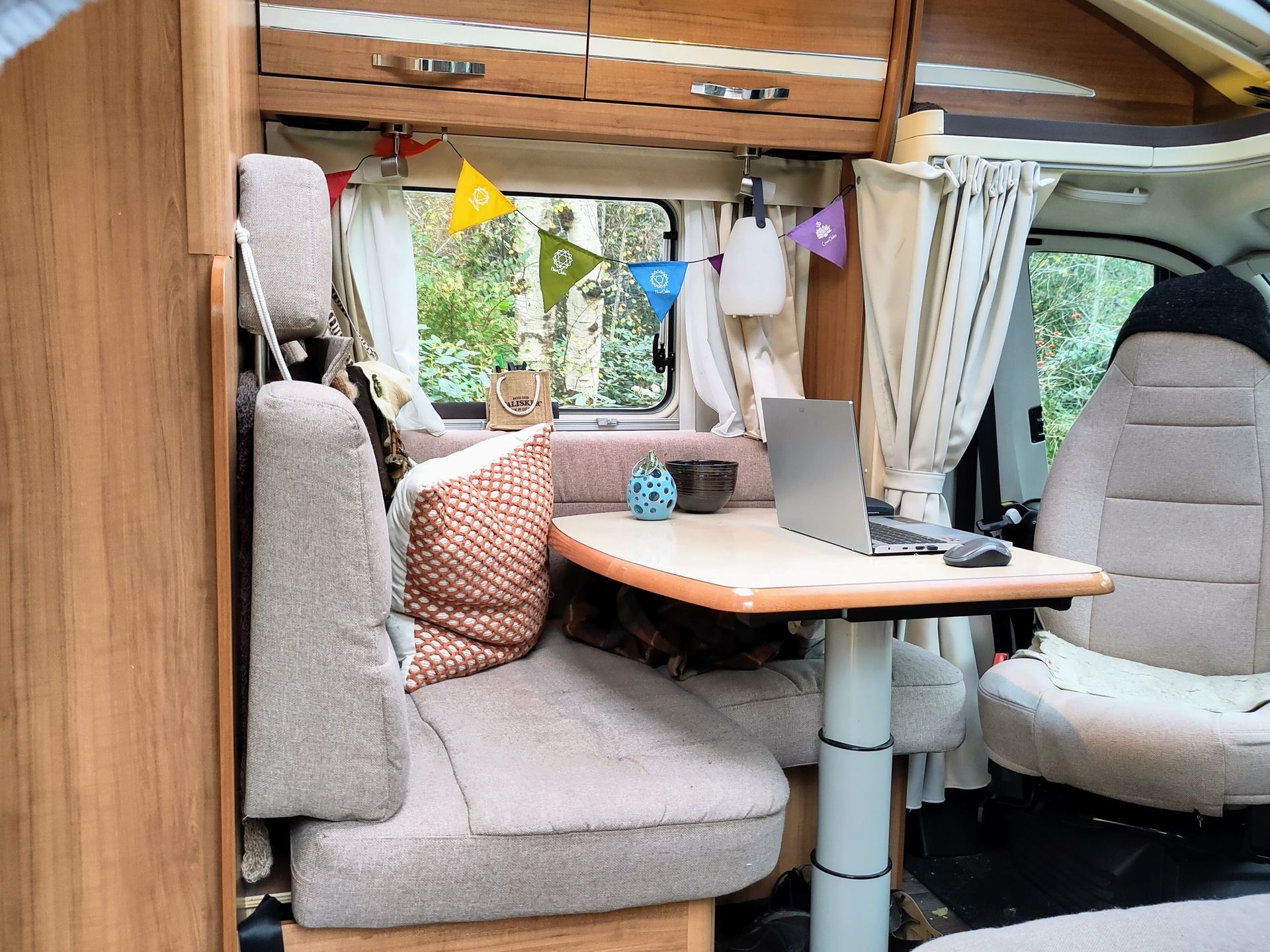 Een camper met een tafel, stoelen en een laptop erop.