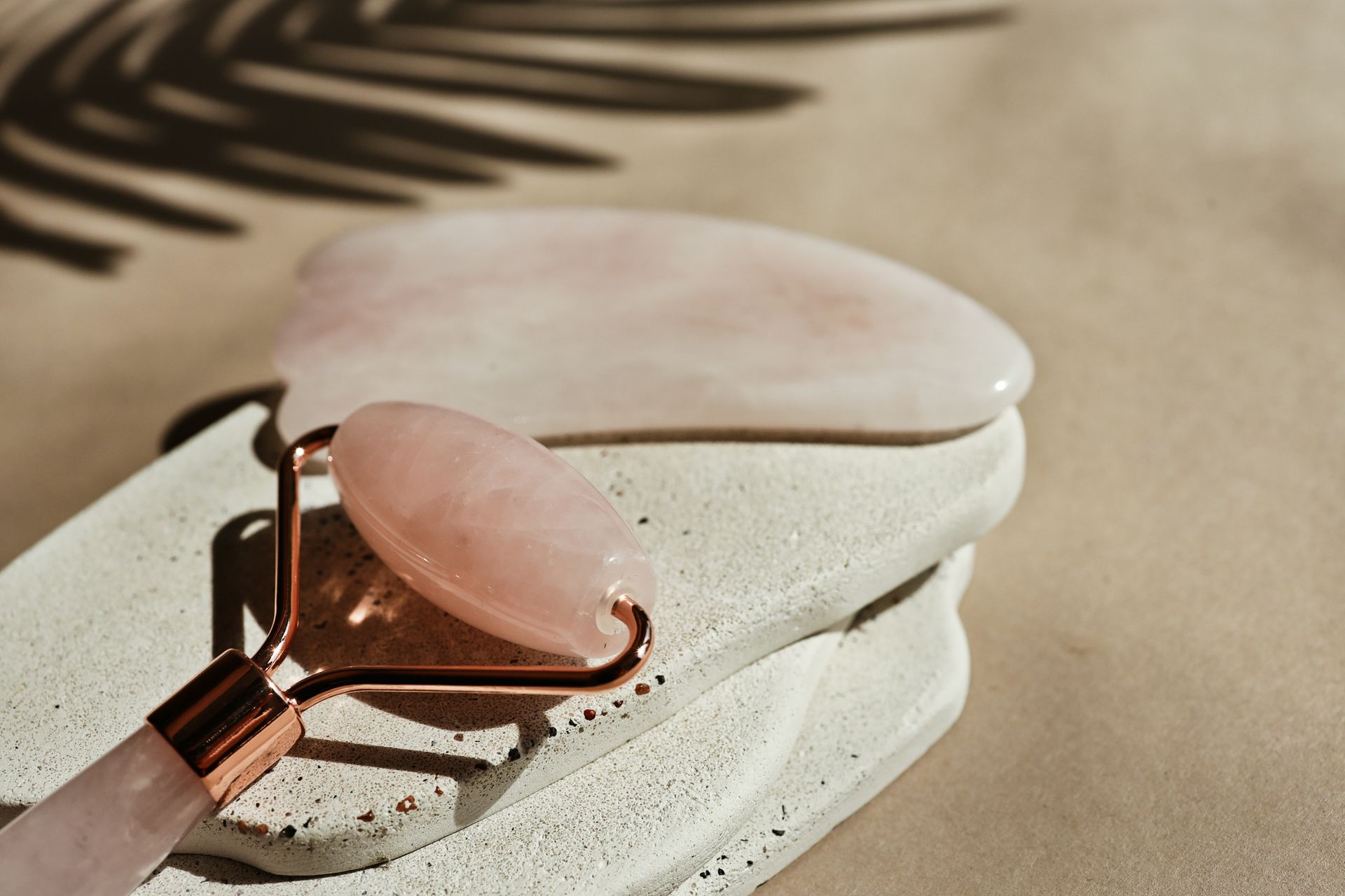 Pink heart-shaped sunglasses on a white stone surface in warm sunlight
