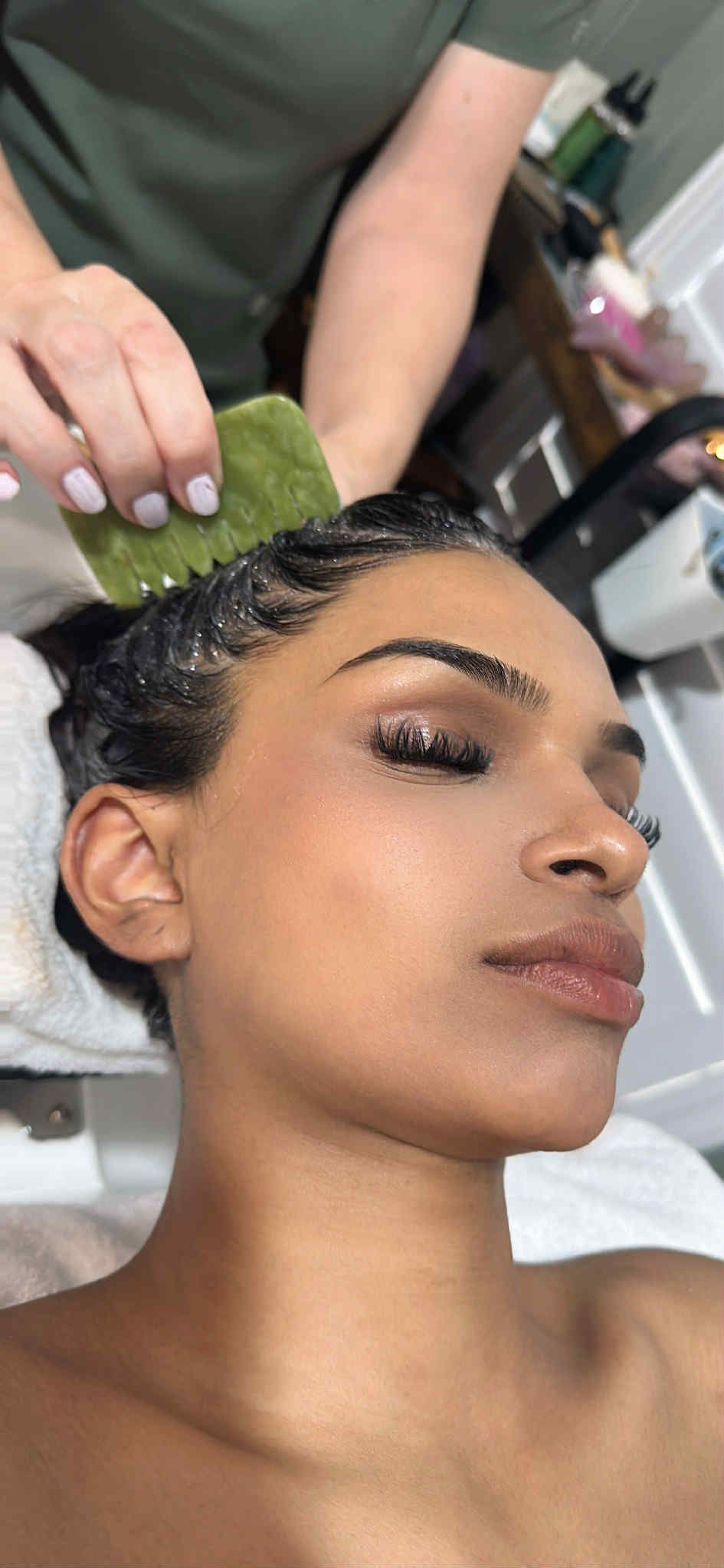 Person lying down while a face mask is applied in a spa setting