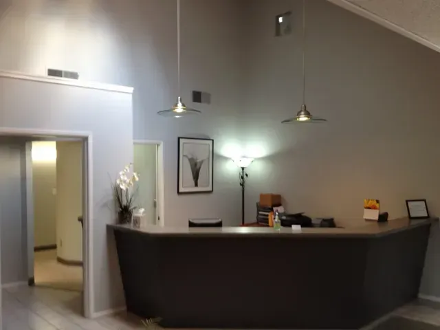 Modern lobby reception desk with pendant lights and framed wall art