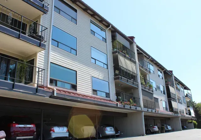 Modern apartment building with balconies and parked cars underneath