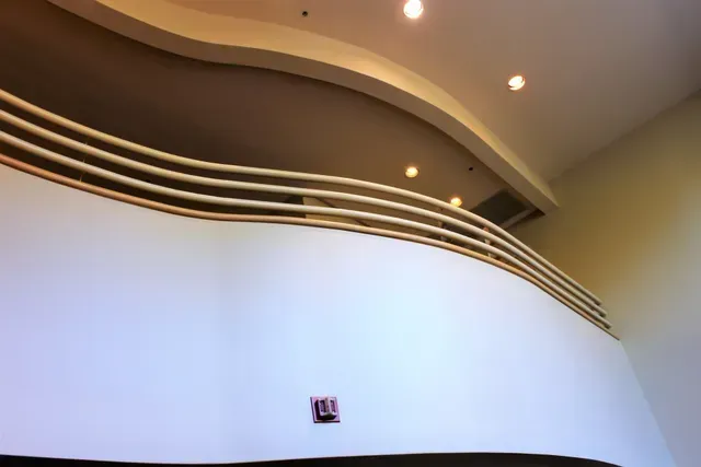 Curved white interior wall with layered dark trim and recessed ceiling lights