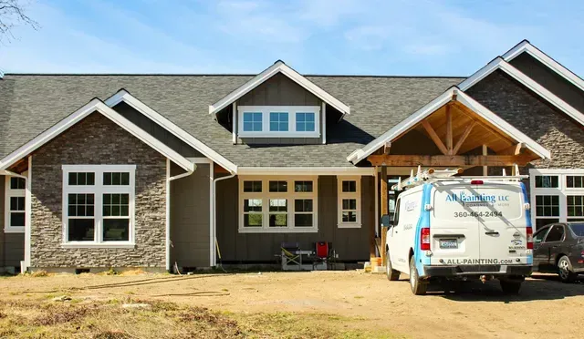 New suburban house under construction with stone facade and a work van parked in front