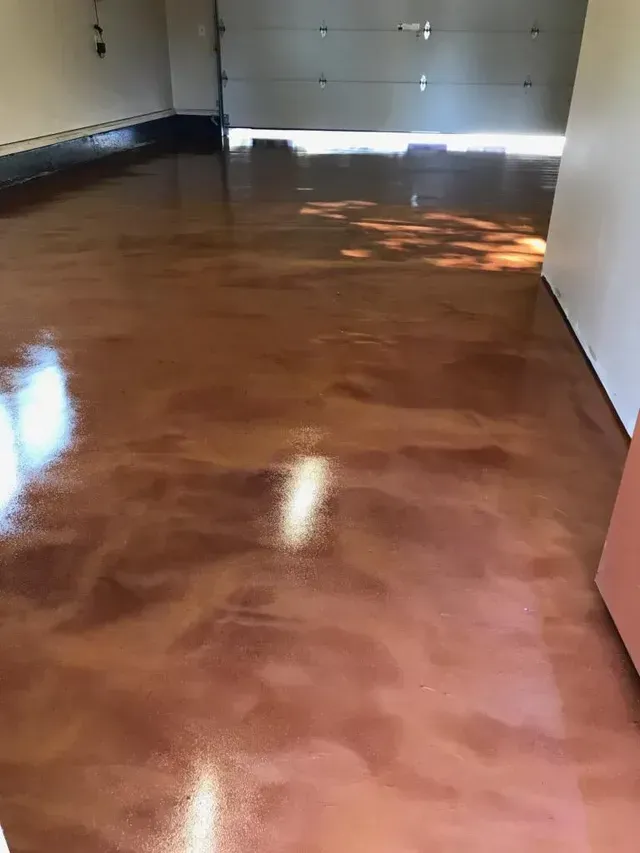 Empty garage with glossy brown floor and sunlight from the open door