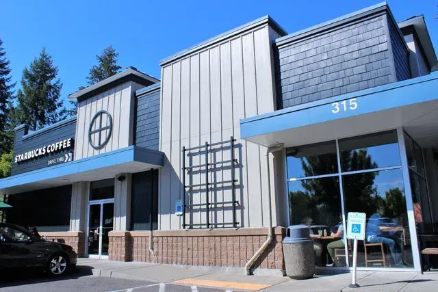 Modern office building with blue awnings, large windows, and the number 315 above the entrance