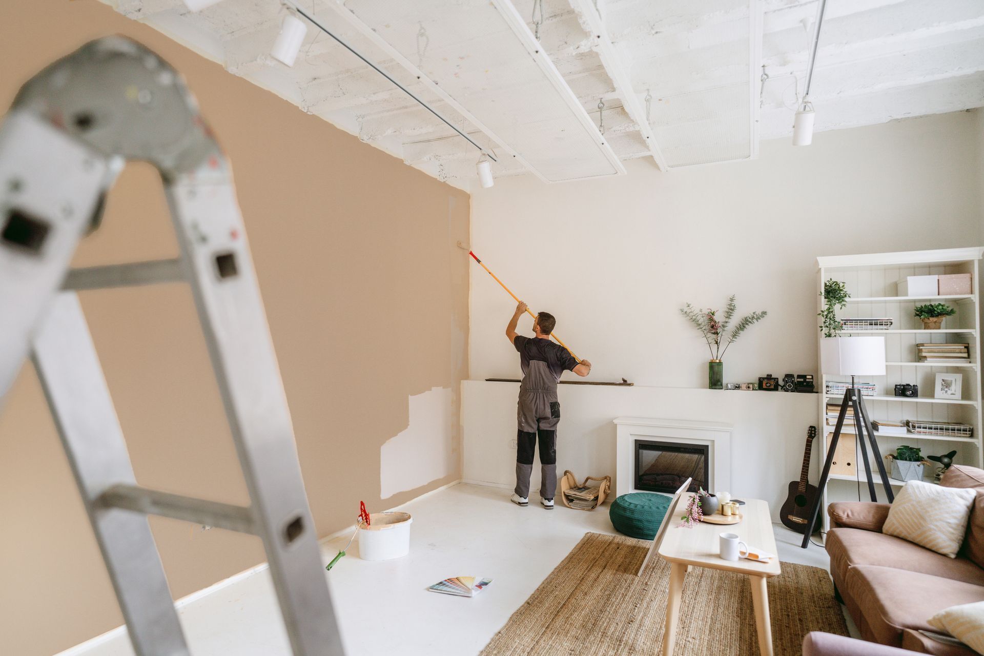 A professional house painter is painting the walls in an apartment. 