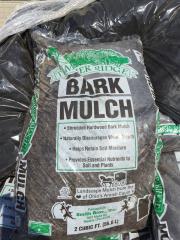 Bag of Water Ridge bark mulch, dark brown, with green and white labels, stacked with other bags.