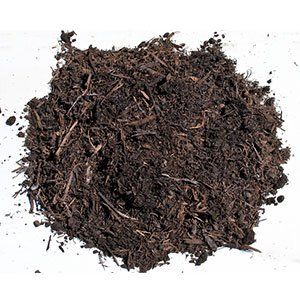 Pile of dark brown mulch on a white surface, composed of various organic materials.